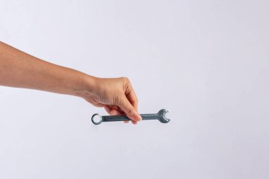 Beyaz arka plan üzerinde izole bir İngiliz anahtarı tutan el.