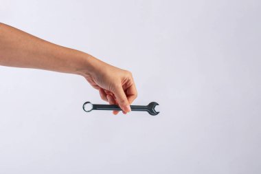 Beyaz arka plan üzerinde izole bir İngiliz anahtarı tutan el.