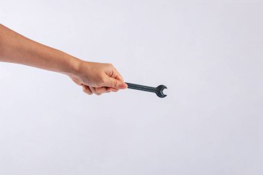 Beyaz arka plan üzerinde izole bir İngiliz anahtarı tutan el.