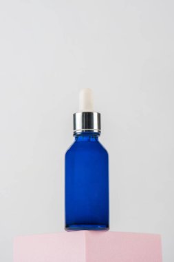 Mavi cam kozmetik şişesi, cilt bakımı ya da beyaz arka planda şık dekorları olan güneş kremi kozmetik ürünleri..