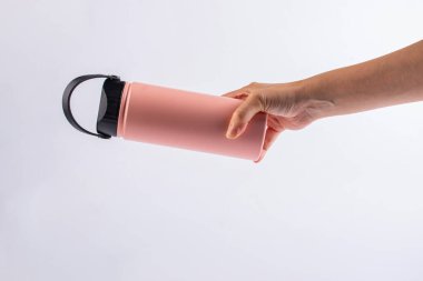 Pembe şişe taklacısı ve beyaz fırında izole edilmiş el.