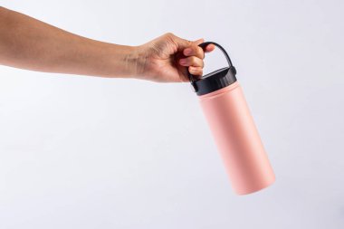 Pembe şişe taklacısı ve beyaz fırında izole edilmiş el.