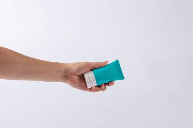 Mavi kozmetik şişesi, cilt bakımı veya beyaz arka planda elde güneş kremi kozmetiği.