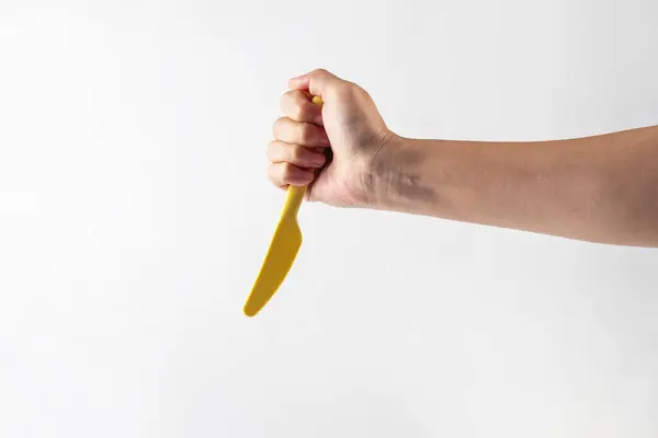 Sarı bıçak ve el beyaz arka planda izole edilmiş.. 