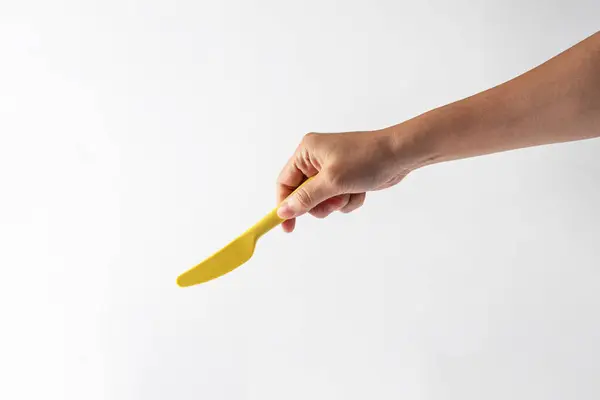 Sarı bıçak ve el beyaz arka planda izole edilmiş.. 