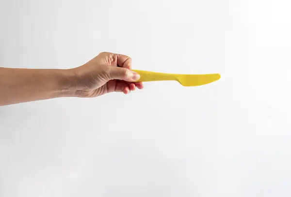 Sarı bıçak ve el beyaz arka planda izole edilmiş.. 