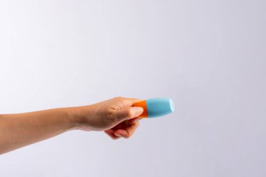 Mavi kozmetik şişesi, cilt bakımı veya beyaz arka planda elde güneş kremi kozmetiği.