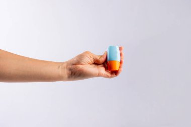 Mavi kozmetik şişesi, cilt bakımı veya beyaz arka planda elde güneş kremi kozmetiği.