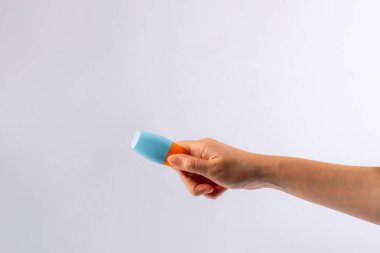 Mavi kozmetik şişesi, cilt bakımı veya beyaz arka planda elde güneş kremi kozmetiği.