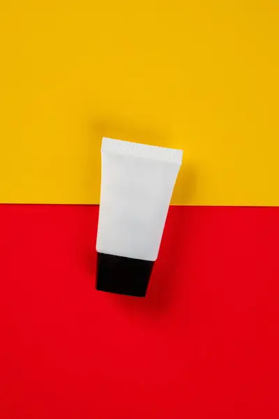 Kozmetik şişe, cilt bakımı veya sarı ve kırmızı arka planda güneş kremi.