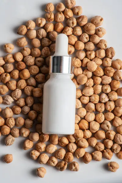 Krem veya losyon için plastik beyaz tüp. Beyaz zemin üzerinde nohut doğal protein kaynağı olan cilt bakımı veya güneş kremi kozmetiği.