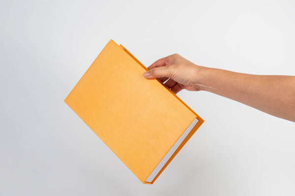 Обложка книги в руке на белом фоне.