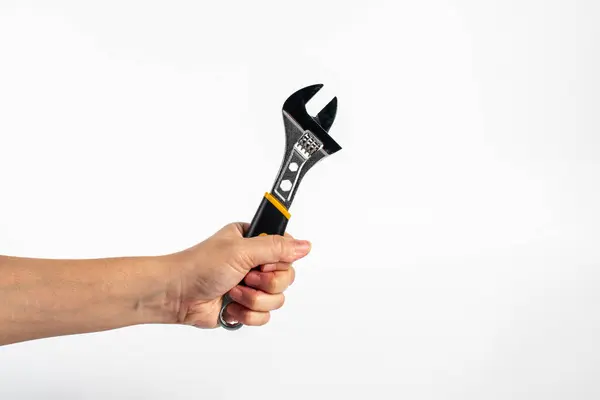 Beyaz arka plan üzerinde izole bir İngiliz anahtarı tutan el.