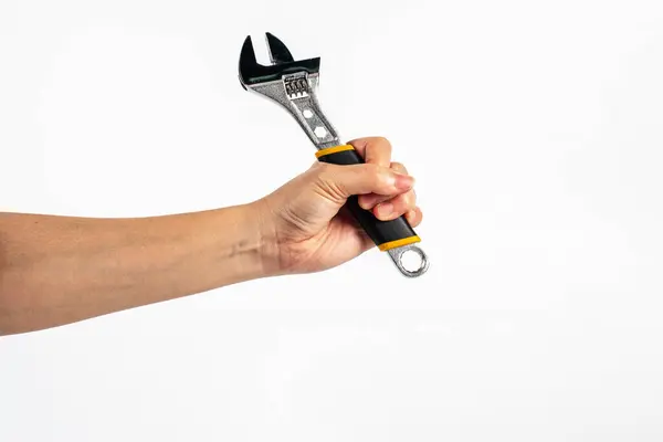 Beyaz arka plan üzerinde izole bir İngiliz anahtarı tutan el.