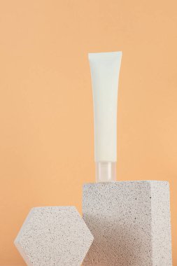Krem veya losyon için plastik beyaz tüp. Krem arkaplanda cilt bakımı veya güneş kremi kozmetiği.