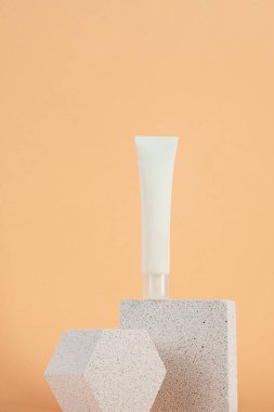 Krem veya losyon için plastik beyaz tüp. Krem arkaplanda cilt bakımı veya güneş kremi kozmetiği.