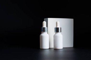 Krem veya losyon için plastik beyaz tüp. Cilt bakımı ya da güneş kremi kozmetik ürünleri siyah arka planda şık dekorlar.