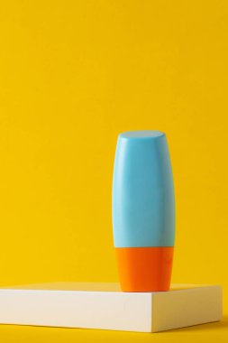 Sarı arka planda nemlendirme için kozmetik ürünü içeren boş bir tüp