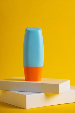 Sarı arka planda nemlendirme için kozmetik ürünü içeren boş bir tüp