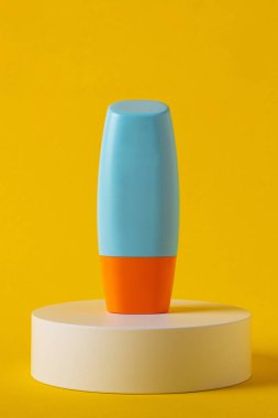 Sarı arka planda nemlendirme için kozmetik ürünü içeren boş bir tüp