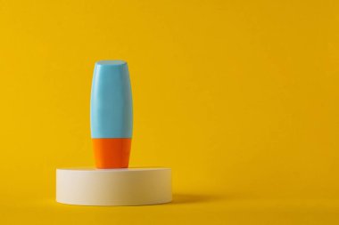 Sarı arka planda nemlendirme için kozmetik ürünü içeren boş bir tüp