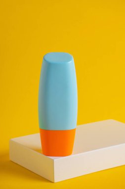 Sarı arka planda nemlendirme için kozmetik ürünü içeren boş bir tüp