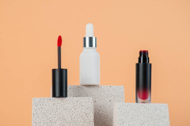 Siyah, boş, ince bir tüp. Rimel, dudak parlatıcısı, jöle, göz kalemi, yağ vs. Krema arka planında şık dekorları olan kozmetik paketler..