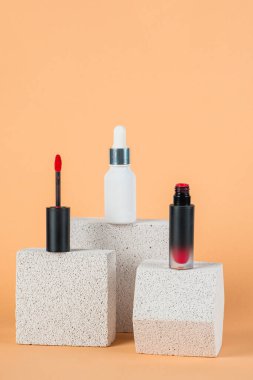 Siyah, boş, ince bir tüp. Rimel, dudak parlatıcısı, jöle, göz kalemi, yağ vs. Krema arka planında şık dekorları olan kozmetik paketler..