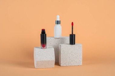 Siyah, boş, ince bir tüp. Rimel, dudak parlatıcısı, jöle, göz kalemi, yağ vs. Krema arka planında şık dekorları olan kozmetik paketler..