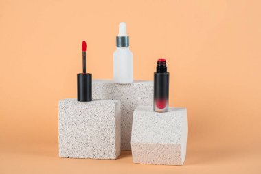 Siyah, boş, ince bir tüp. Rimel, dudak parlatıcısı, jöle, göz kalemi, yağ vs. Krema arka planında şık dekorları olan kozmetik paketler..