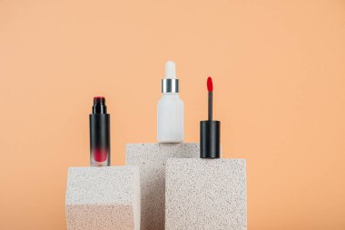 Siyah, boş, ince bir tüp. Rimel, dudak parlatıcısı, jöle, göz kalemi, yağ vs. Krema arka planında şık dekorları olan kozmetik paketler..