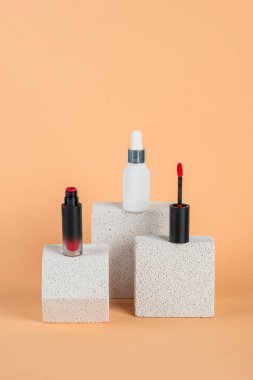 Siyah, boş, ince bir tüp. Rimel, dudak parlatıcısı, jöle, göz kalemi, yağ vs. Krema arka planında şık dekorları olan kozmetik paketler..