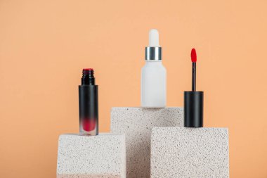 Siyah, boş, ince bir tüp. Rimel, dudak parlatıcısı, jöle, göz kalemi, yağ vs. Krema arka planında şık dekorları olan kozmetik paketler..