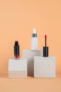 Siyah, boş, ince bir tüp. Rimel, dudak parlatıcısı, jöle, göz kalemi, yağ vs. Krema arka planında şık dekorları olan kozmetik paketler..