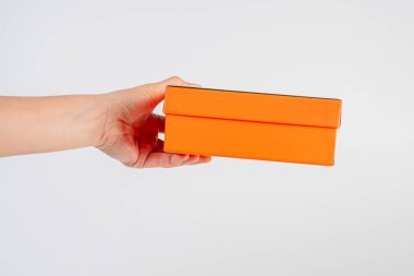 Eldeki turuncu kutu beyaz arkaplanda izole edildi 