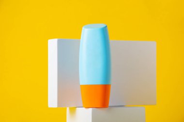 Sarı arka planda nemlendirme için kozmetik ürünü içeren boş bir tüp