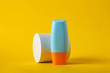 Sarı arka planda nemlendirme için kozmetik ürünü içeren boş bir tüp