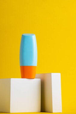 Sarı arka planda nemlendirme için kozmetik ürünü içeren boş bir tüp