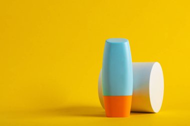 Sarı arka planda nemlendirme için kozmetik ürünü içeren boş bir tüp