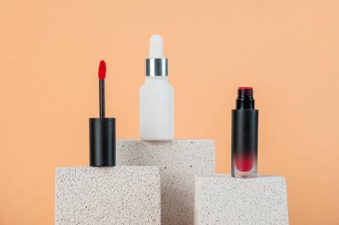 Siyah, boş, ince bir tüp. Rimel, dudak parlatıcısı, jöle, göz kalemi, yağ vs. Krema arka planında şık dekorları olan kozmetik paketler..