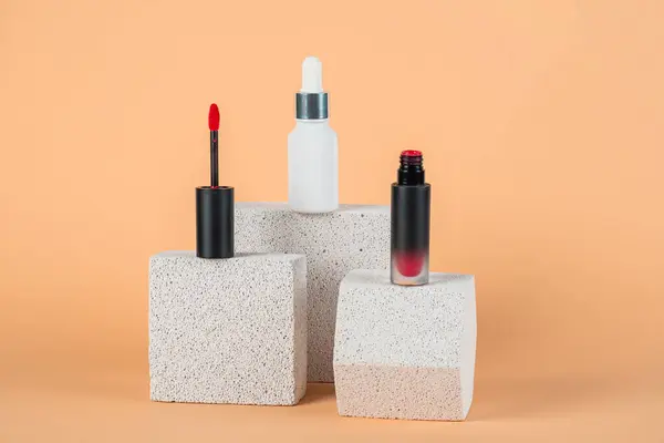 Siyah, boş, ince bir tüp. Rimel, dudak parlatıcısı, jöle, göz kalemi, yağ vs. Krema arka planında şık dekorları olan kozmetik paketler..