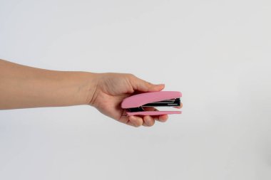 Beyaz arkaplanda pembe zımba var.