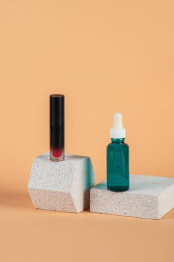 Siyah, boş, ince bir tüp. Rimel, dudak parlatıcısı, jöle, göz kalemi, yağ vs. Krema arka planında şık dekorları olan kozmetik paketler..