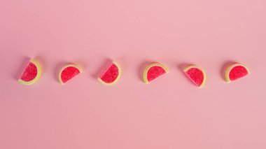 Pembe arka planda şekerle karışık meyveli jöle.