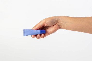 Beyaz arkaplanda krem, güneş kremi veya serum için mor paket.