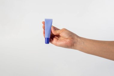 Beyaz arkaplanda krem, güneş kremi veya serum için mor paket.