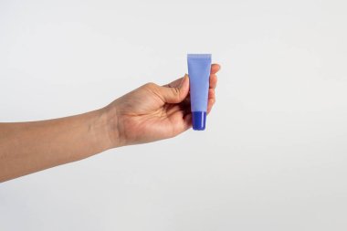 Beyaz arkaplanda krem, güneş kremi veya serum için mor paket.