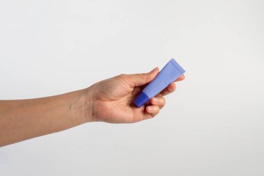 Beyaz arkaplanda krem, güneş kremi veya serum için mor paket.