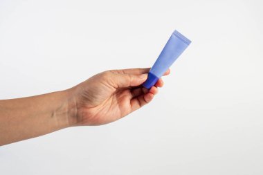 Beyaz arkaplanda krem, güneş kremi veya serum için mor paket.