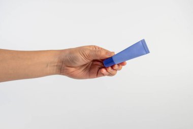 Beyaz arkaplanda krem, güneş kremi veya serum için mor paket.